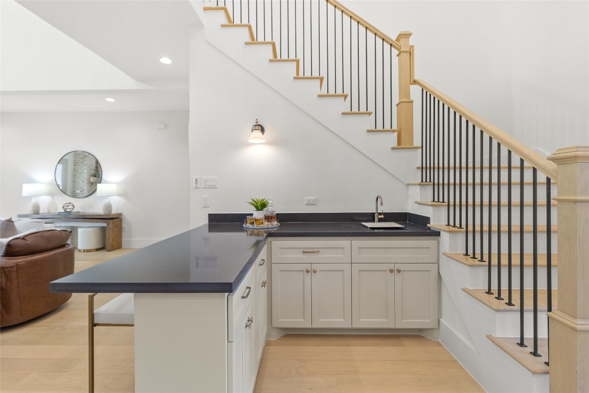 7115 Raton Street Houston, TX 77055 - Photo 9 of 49 This tucked-in wet bar adds a smart layer of functionality right where you need it. Positioned beneath the staircase, it’s perfect for serving drinks, setting up a coffee station, or hosting without running back to the kitchen. The contrast countertop and integrated sink make it feel intentional and elevated—an everyday convenience that quietly upgrades how you entertain.