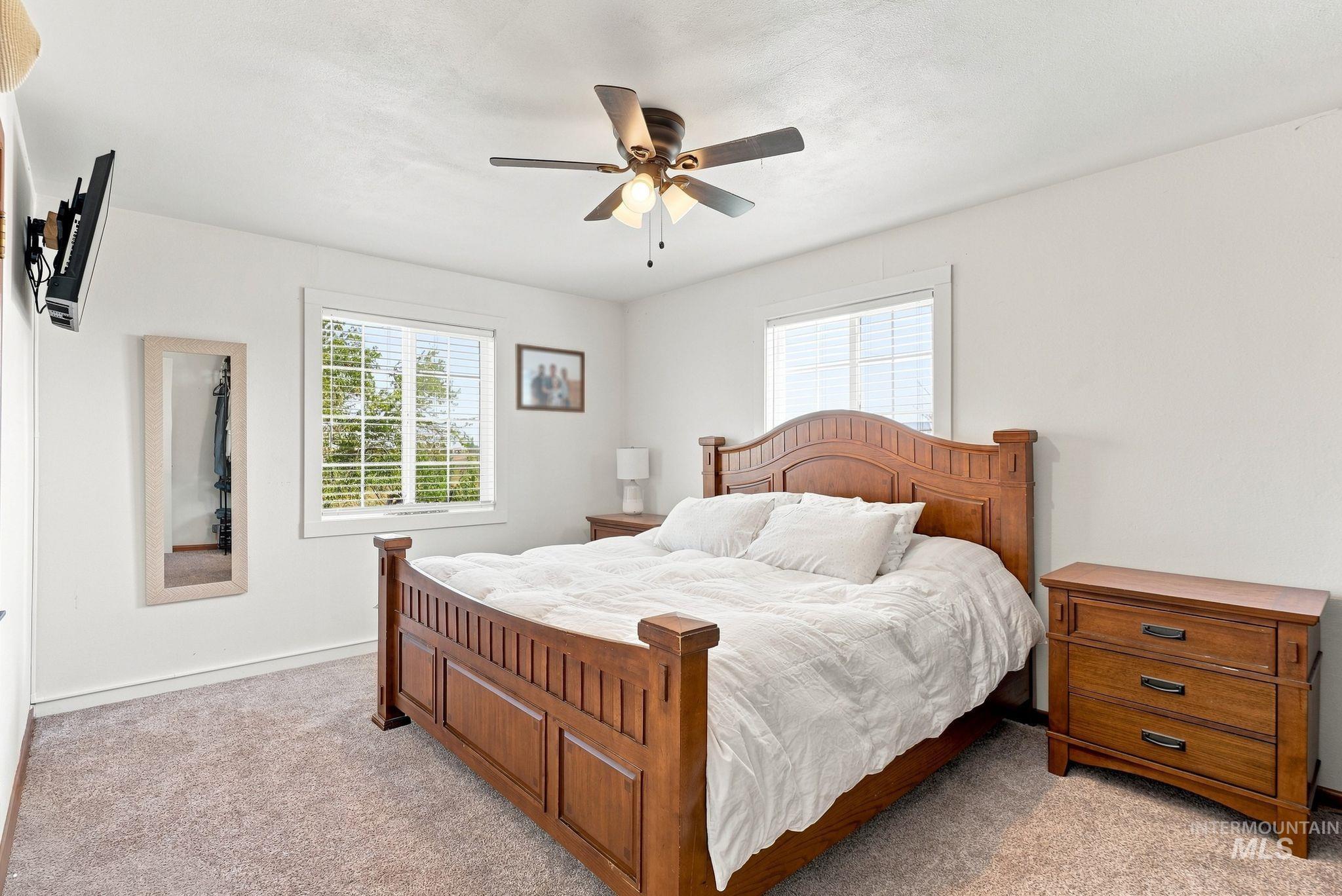 16078 Hoffman Road Kendrick, ID 83537 - Photo 17 of 47 Bright interior with two windows, ceiling fan, and light-colored carpeting