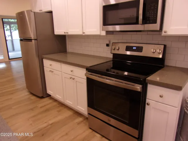 a kitchen with stainless steel appliances wooden cabinets sink and microwave