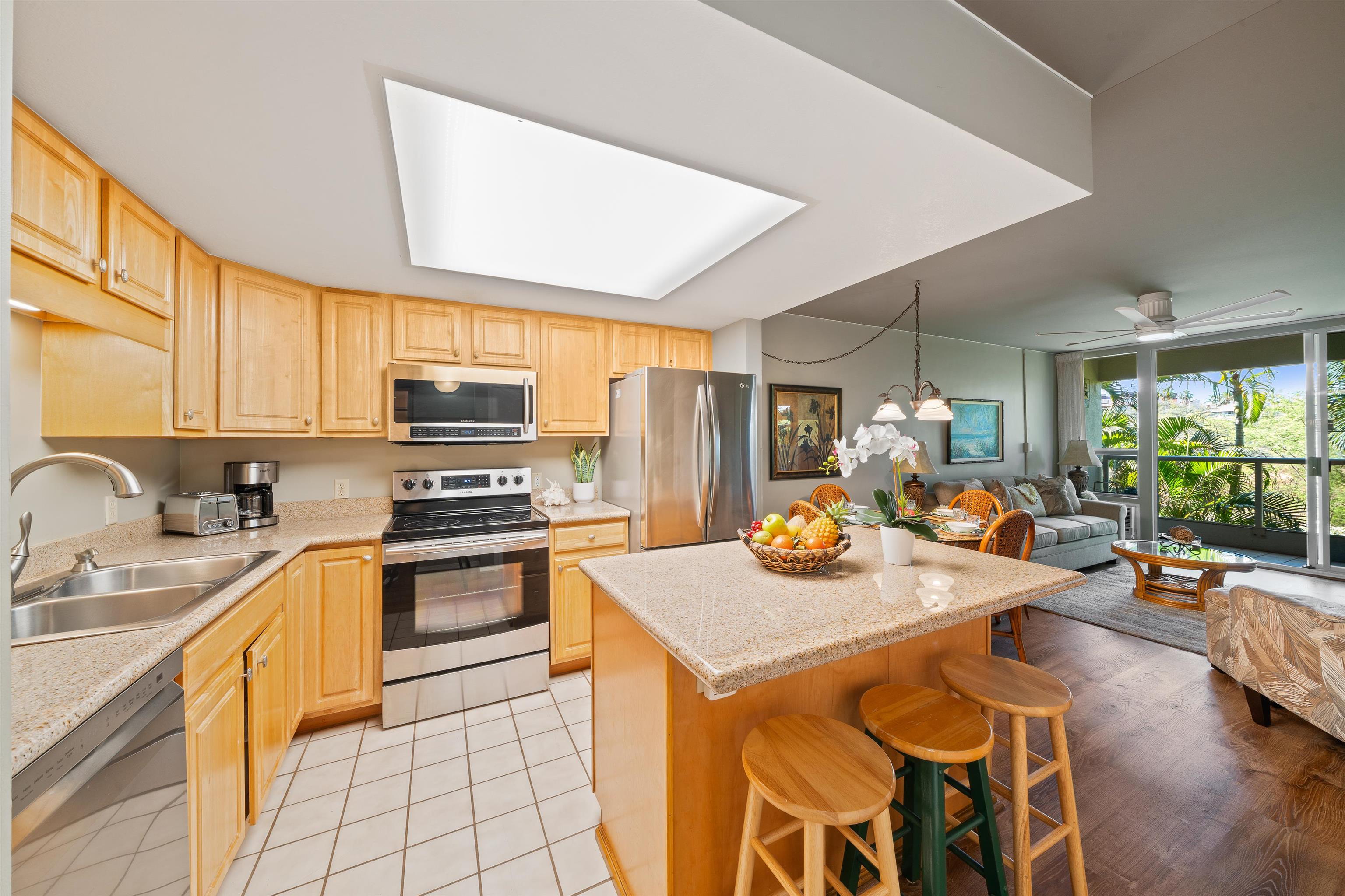 2575 South Kihei Road, Unit H207 Kihei, HI 96753 - Photo 12 of 31 a kitchen with a stove a sink a refrigerator dining table and chairs