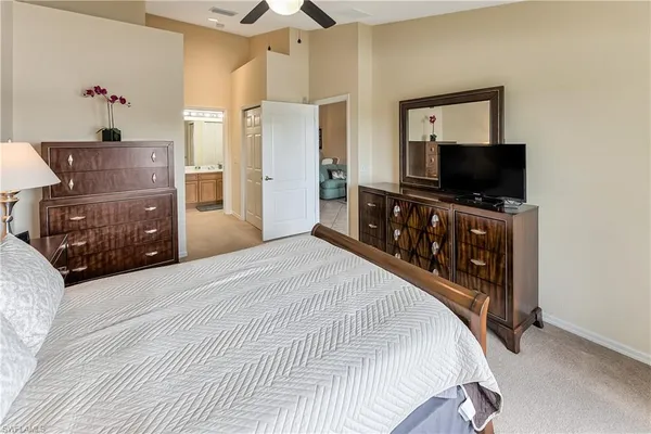 a bedroom with a bed and a flat tv screen on dresser
