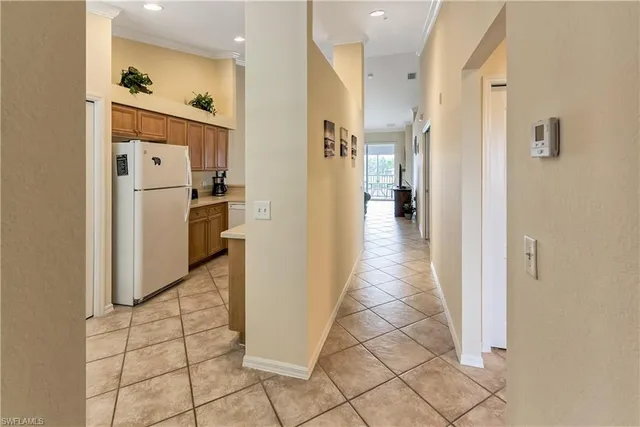 a view of a hallway with wooden floor and a living room