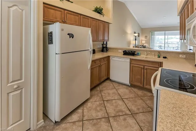 a kitchen with a refrigerator sink and cabinets