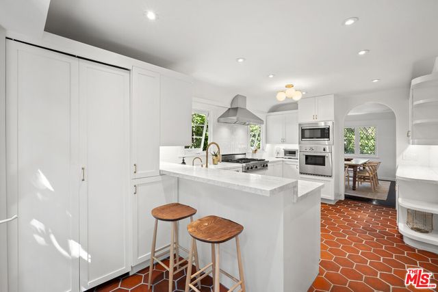 a backyard of a house with table and chairs plants and large trees