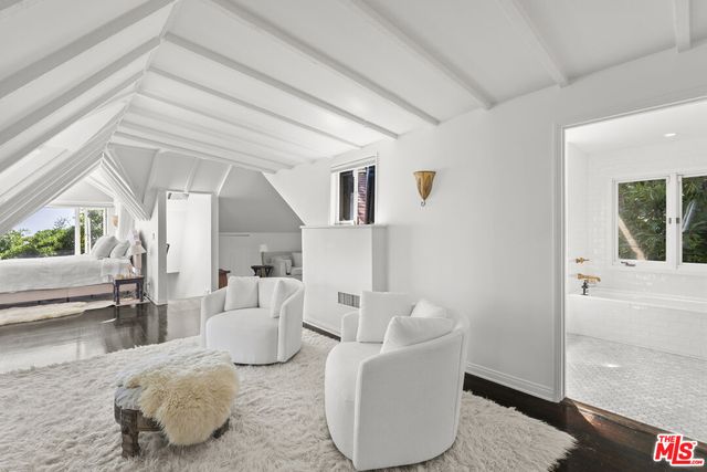 a living room with a bed furniture and a large window