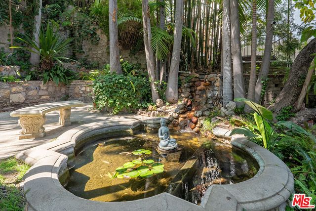 a view of a patio with table and chairs potted plants and palm tree