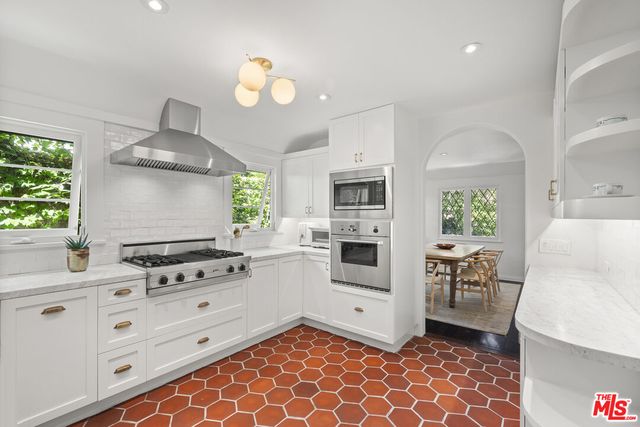 a kitchen with white cabinets stainless steel appliances and sink