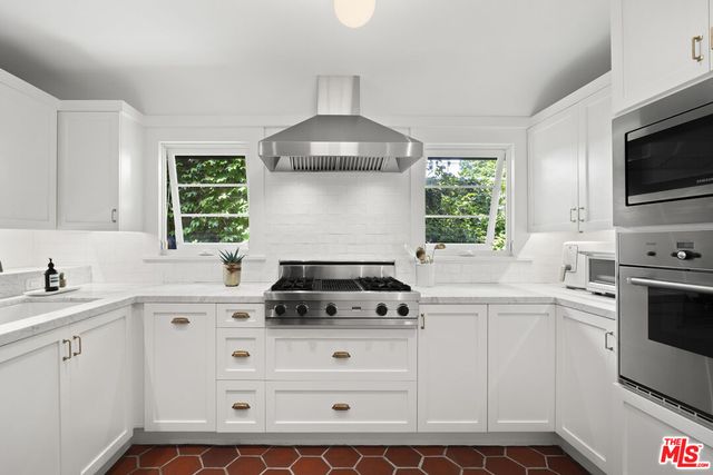 a kitchen that has a sink and a stove in it