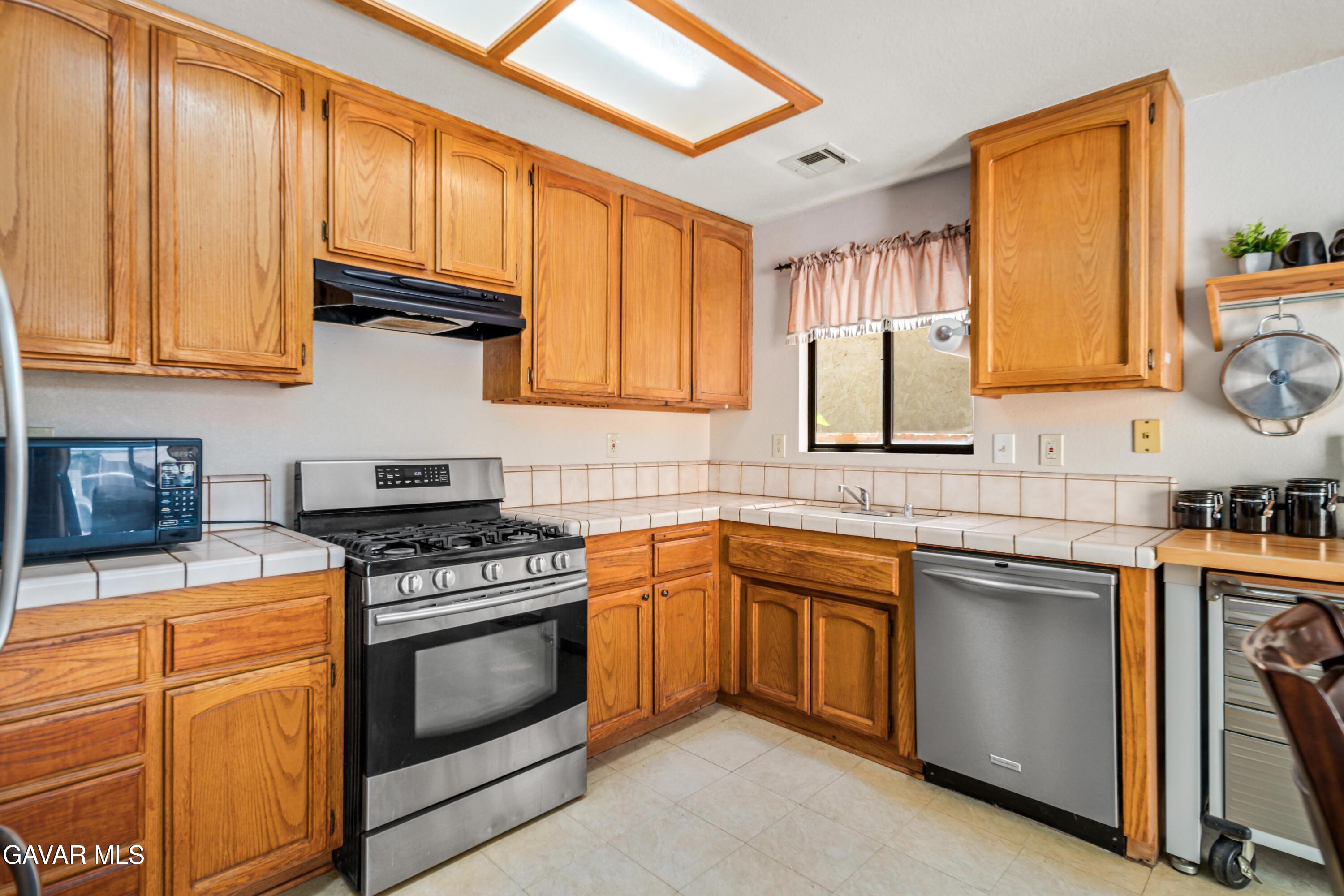 43230 Lookabout Road Lake Hughes, CA 93532 - Photo 7 of 35 a kitchen with stainless steel appliances granite countertop a stove sink and cabinets