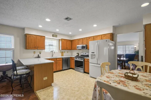 a kitchen with refrigerator and chairs