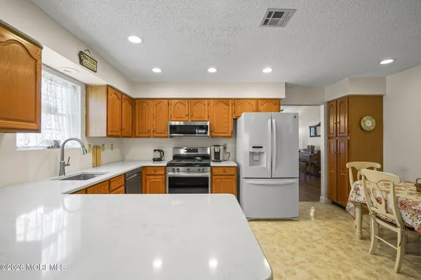 a kitchen with stainless steel appliances granite countertop a refrigerator stove microwave and sink