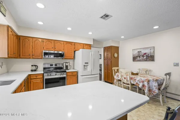 a kitchen with stainless steel appliances granite countertop a refrigerator stove microwave and sink