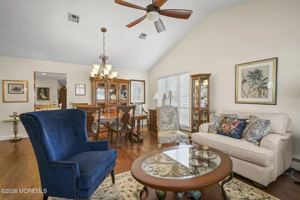 a living room with furniture a chandelier and a table