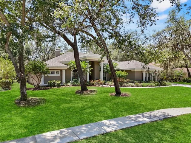 a kitchen with stainless steel appliances a sink a stove a refrigerator a center island and chairs