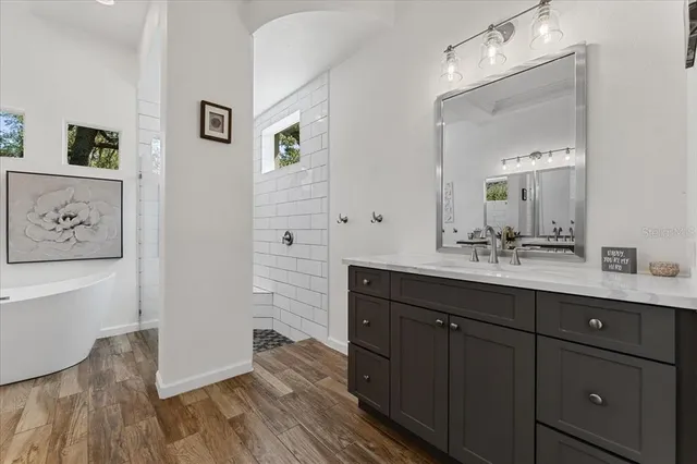 a kitchen with a sink and a stove with wooden floor