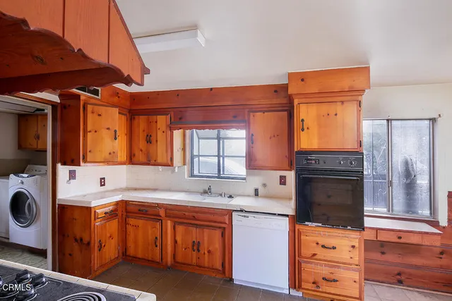 a kitchen with granite countertop a sink stove and cabinets