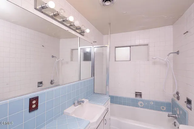 a bathroom with a tub a sink and mirror