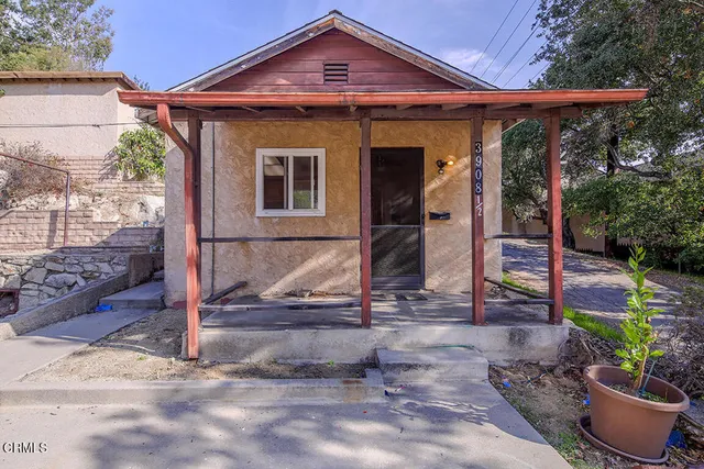 a view of an empty room with window and a kitchen