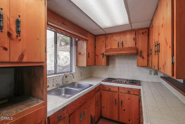 a kitchen with stainless steel appliances granite countertop a sink a stove and a refrigerator