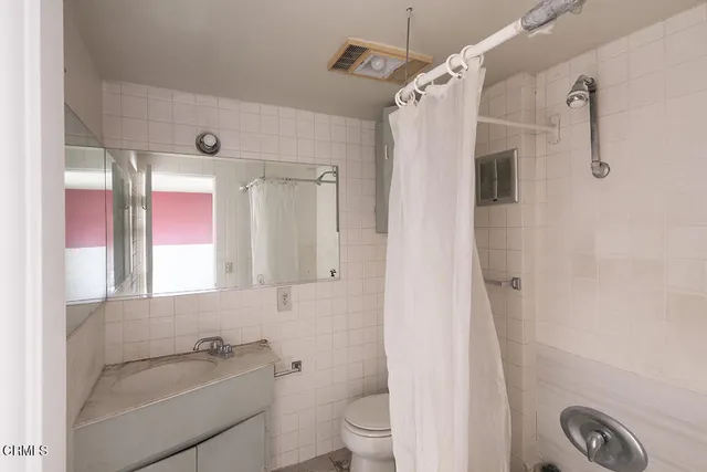 a view of a small house with wooden fence