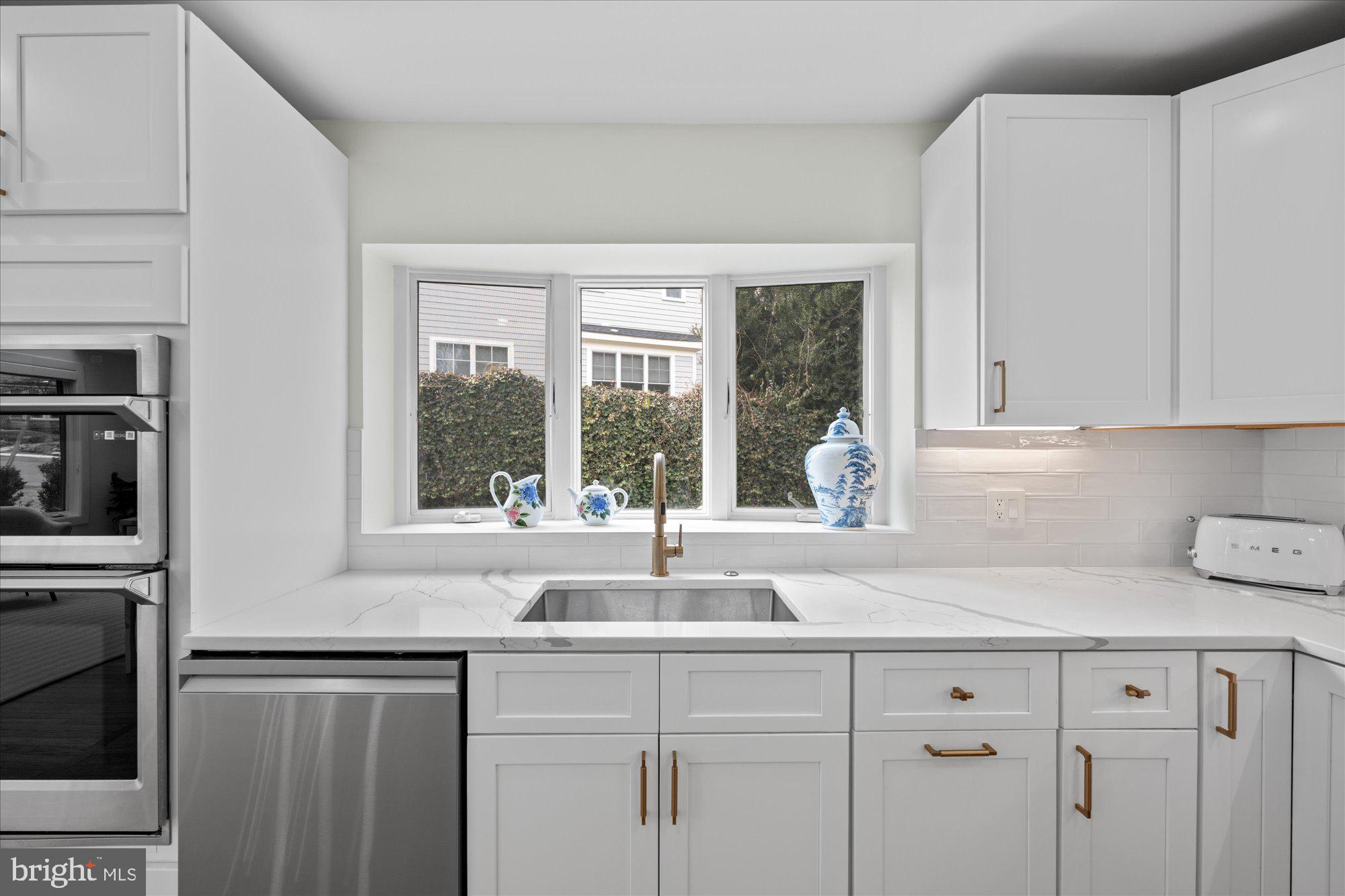 6700 Rannoch Road Bethesda, MD 20817 - Photo 14 of 36 a kitchen with stainless steel appliances granite countertop white cabinets and a window