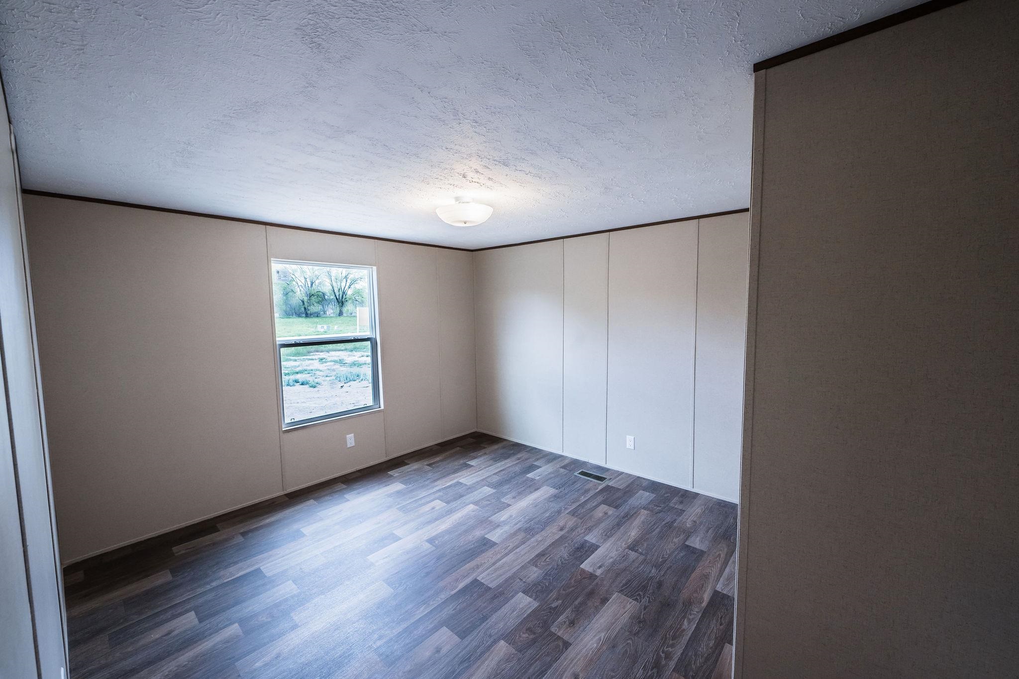 283 Clements Way Fruita, CO 81521 - Photo 12 of 16 an empty room with wooden floor and windows