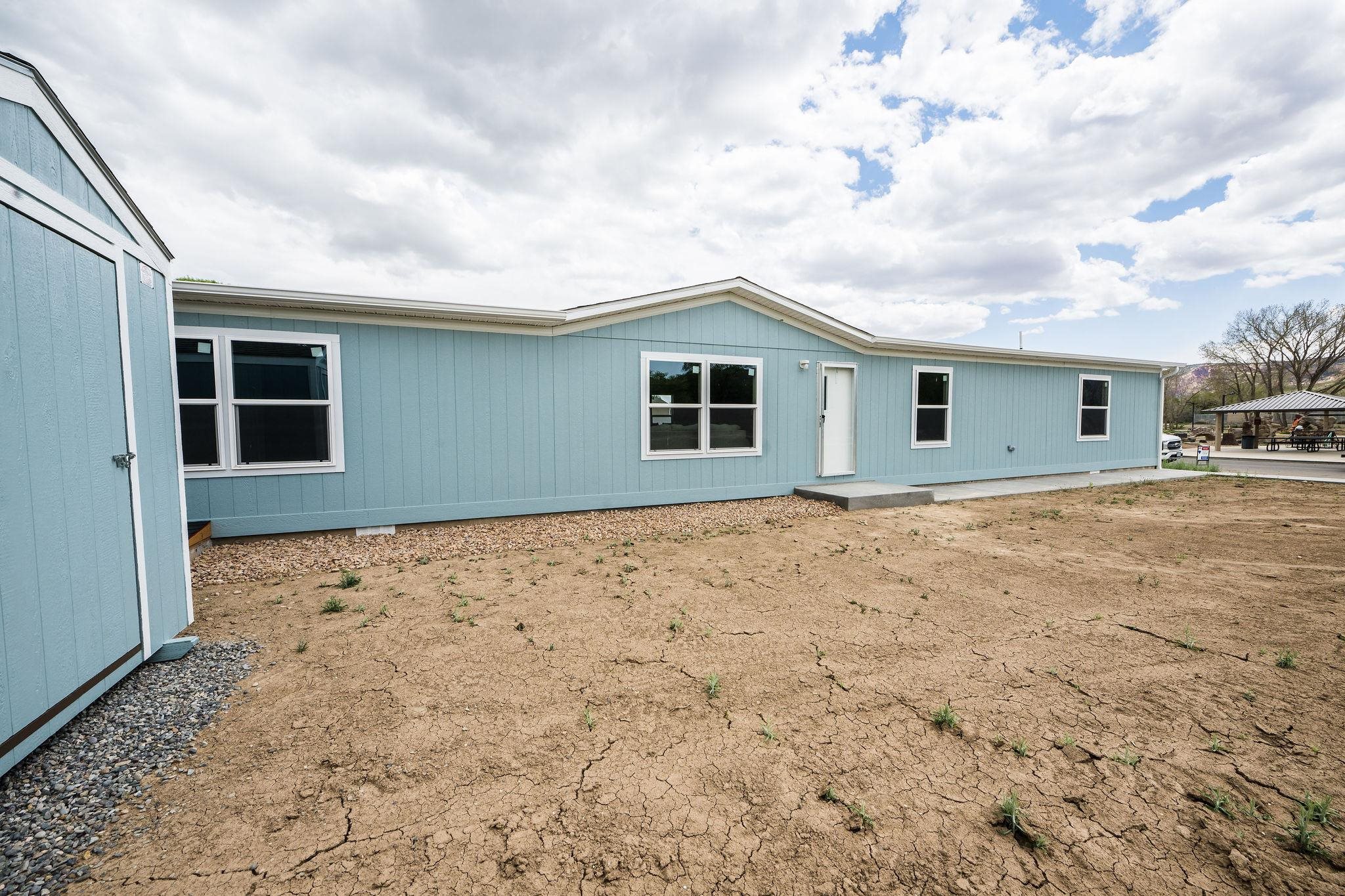 283 Clements Way Fruita, CO 81521 - Photo 2 of 16 a backyard of a house with wooden fence and large windows