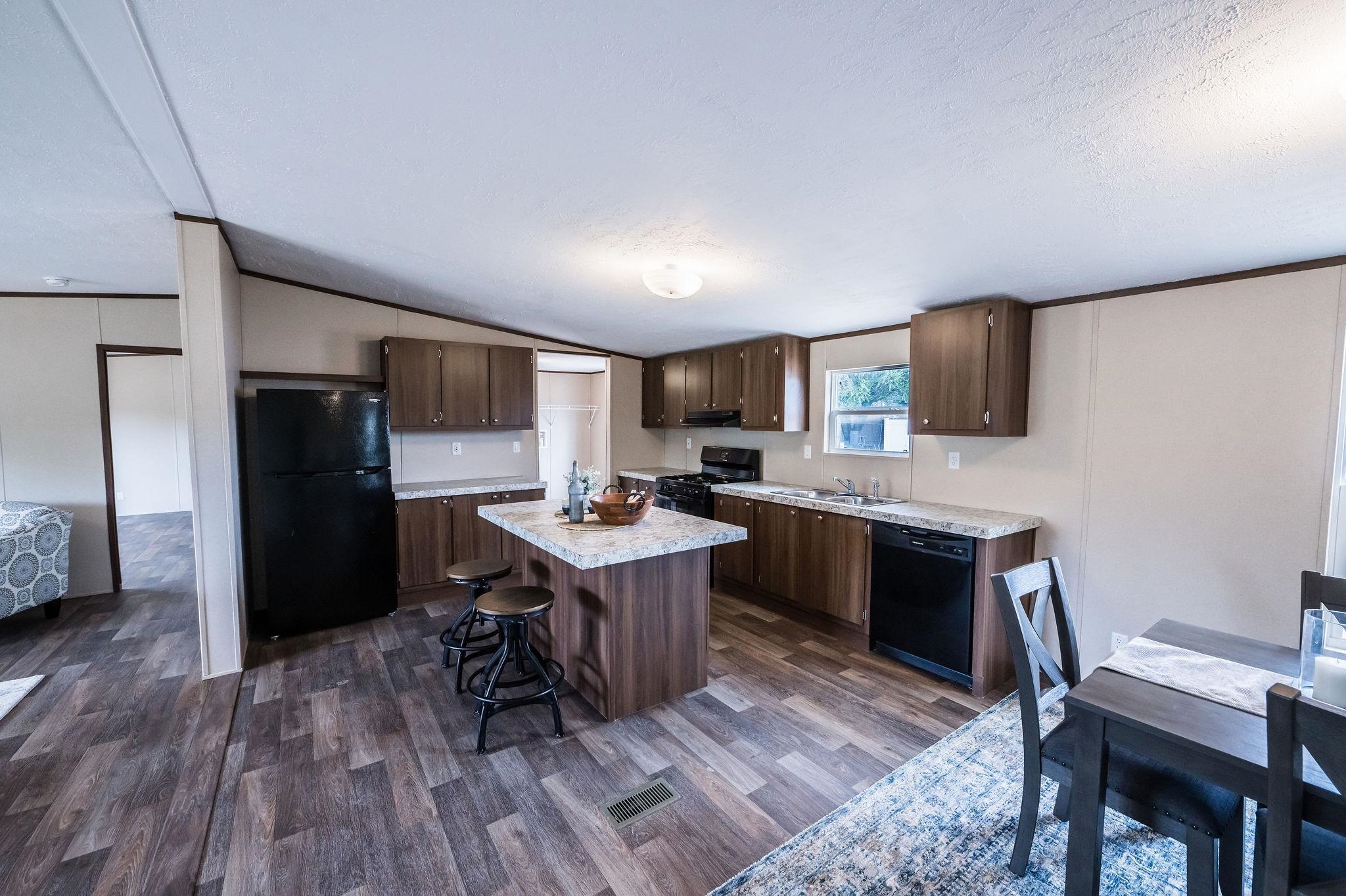 283 Clements Way Fruita, CO 81521 - Photo 7 of 16 a kitchen with a refrigerator a stove a sink dishwasher and a dining table with wooden floor