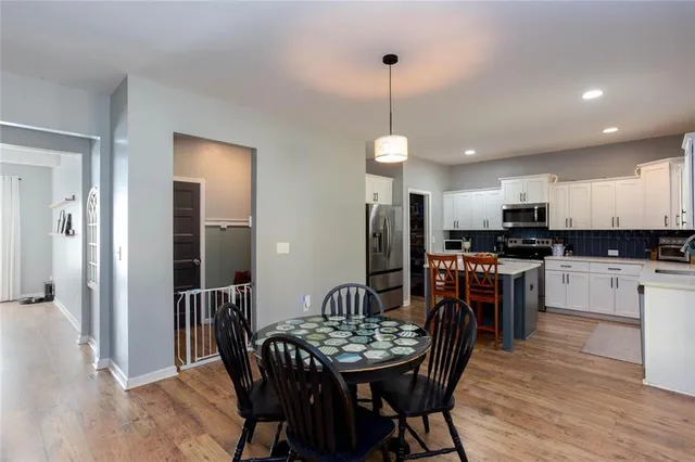 a kitchen with stainless steel appliances kitchen island granite countertop a dining table chairs and granite counter tops