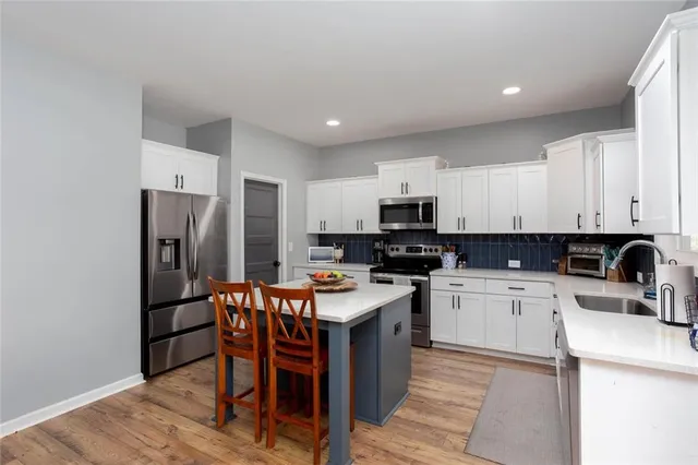 a kitchen with stainless steel appliances granite countertop a refrigerator a stove top oven a sink and dishwasher