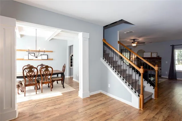 a dining room with furniture entryway and wooden floor