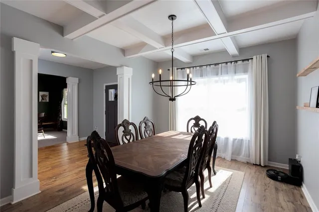 a view of a dining room and livingroom with furniture wooden floor a chandelier