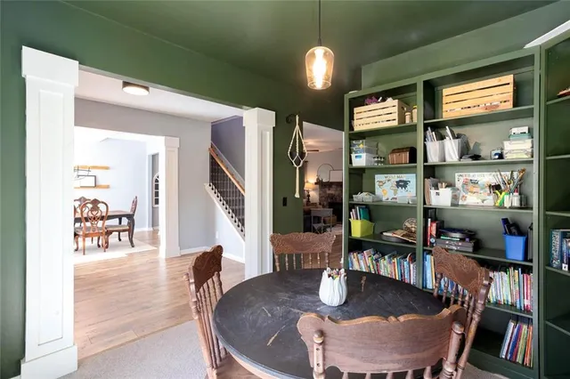 a dining room with furniture a book and wooden floor