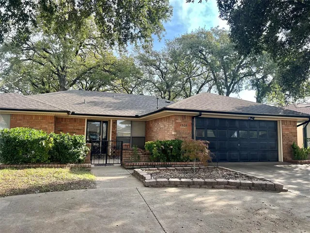 a front view of a house with a yard and potted plants