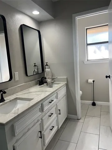 a bathroom with a double vanity sink and a mirror