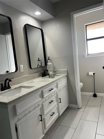 a view of a hallway with wooden floor and a bathroom