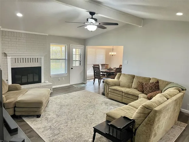 a living room with furniture kitchen view and a large window