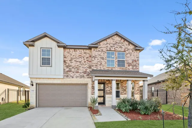 a front view of a house with yard and garage