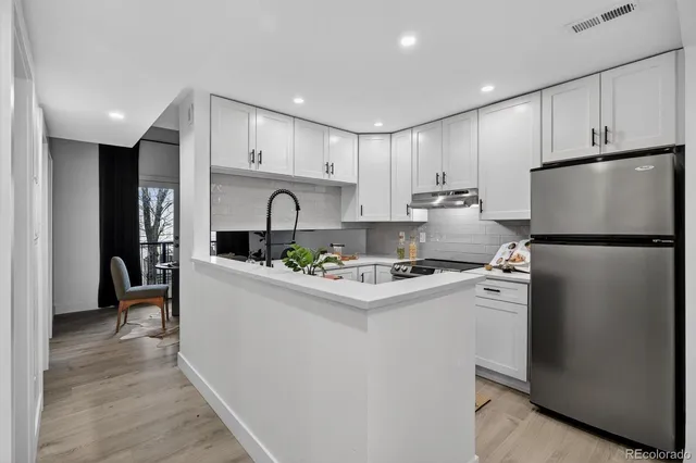a kitchen with kitchen island stainless steel appliances a refrigerator sink and cabinets