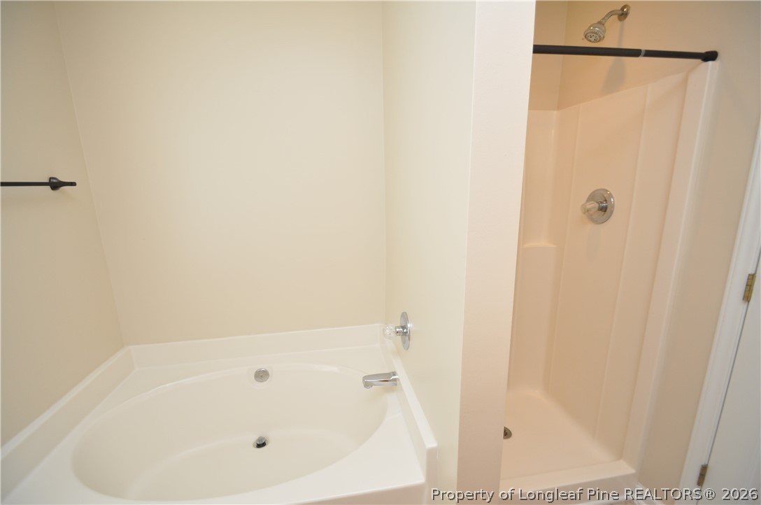 1404 Woodline Drive Raleigh, NC 27603 - Photo 19 of 35 a bathroom with a white bath tub and a shower