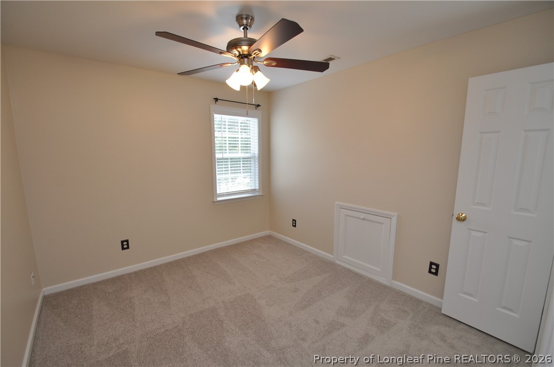 1404 Woodline Drive Raleigh, NC 27603 - Photo 26 of 35 an empty room with a chandelier fan and windows