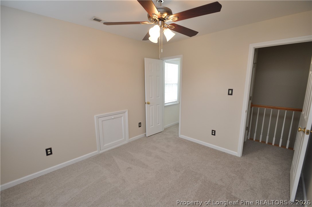 1404 Woodline Drive Raleigh, NC 27603 - Photo 27 of 35 an empty room with chandelier fan and windows
