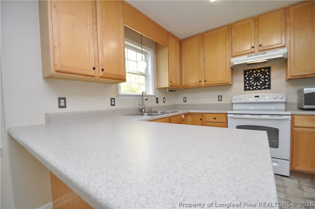 1404 Woodline Drive Raleigh, NC 27603 - Photo 10 of 35 a kitchen with a white cabinets and white appliances