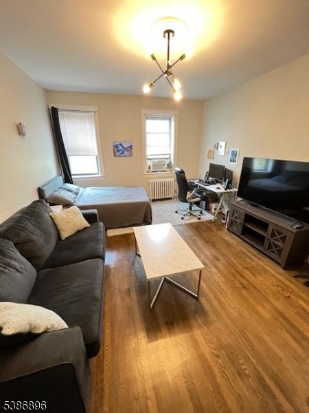 303 Hamilton Place, Unit D4 Hackensack, NJ 07601 - Photo 3 of 8 a living room with furniture a window and a flat screen tv