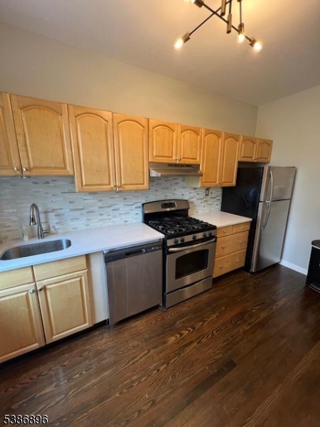 303 Hamilton Place, Unit D4 Hackensack, NJ 07601 - Photo 4 of 8 a kitchen with stainless steel appliances a sink cabinets and wooden floor