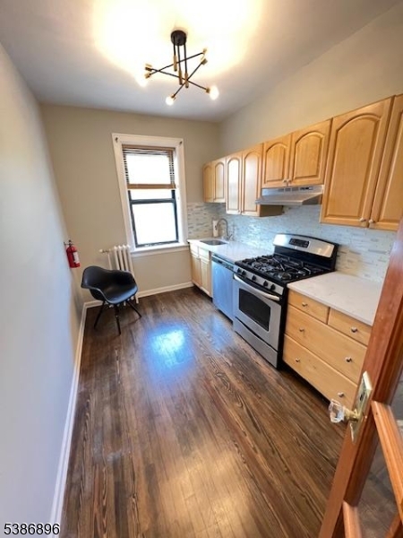 303 Hamilton Place, Unit D4 Hackensack, NJ 07601 - Photo 5 of 8 a kitchen with granite countertop a stove and a refrigerator