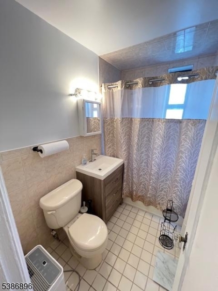 303 Hamilton Place, Unit D4 Hackensack, NJ 07601 - Photo 6 of 8 a bathroom with a sink mirror vanity and toilet