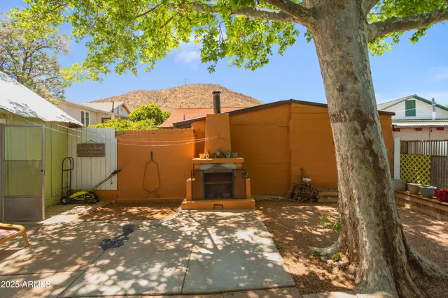 a view of a patio with table and chairs under an umbrella with wooden fence