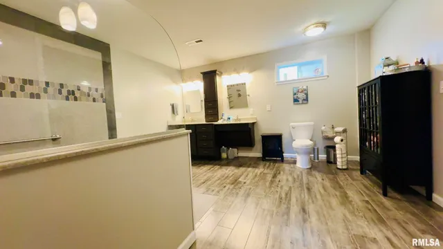 a bedroom with a bed a flat screen tv and dresser