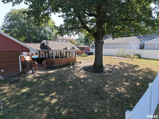 a view of a house with backyard and trees